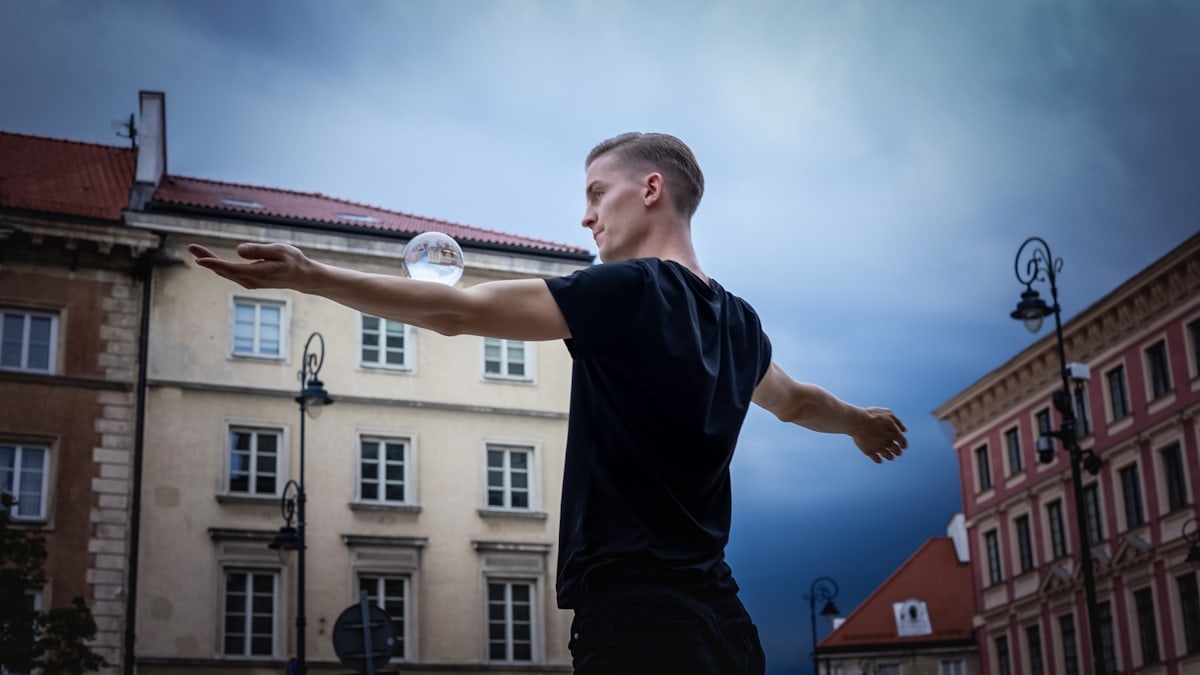 man in black t-shirt and black pants standing on roof top during daytime
